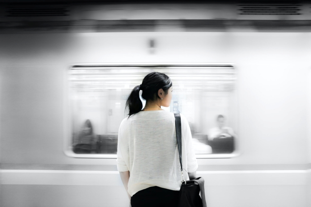 駅のホームに立つ女性の後ろ姿